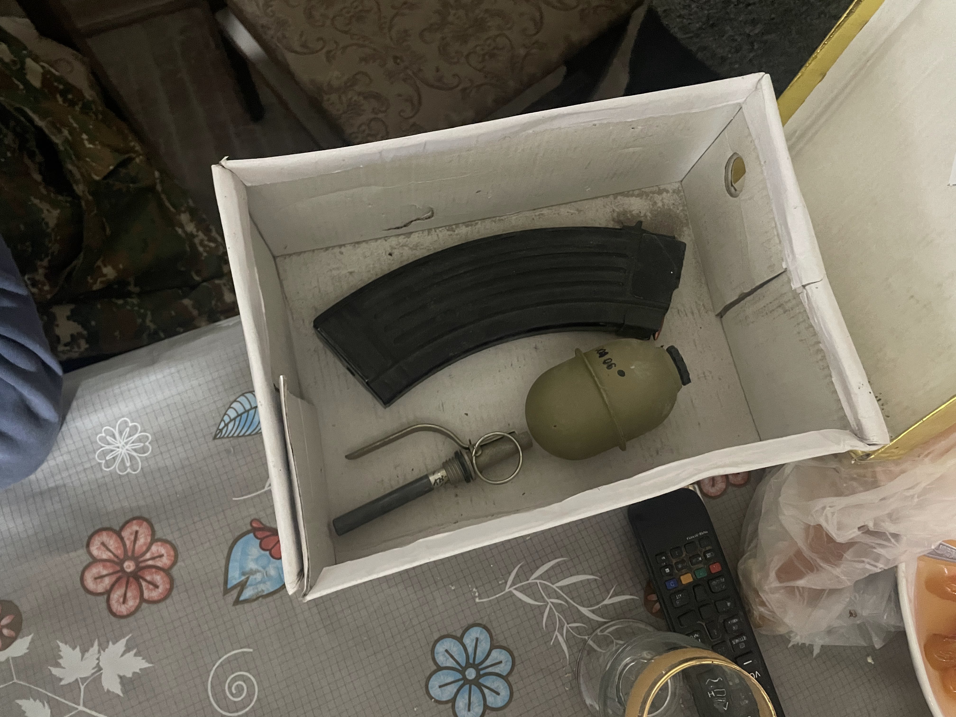 Grenade and ammo in a cardboard box.